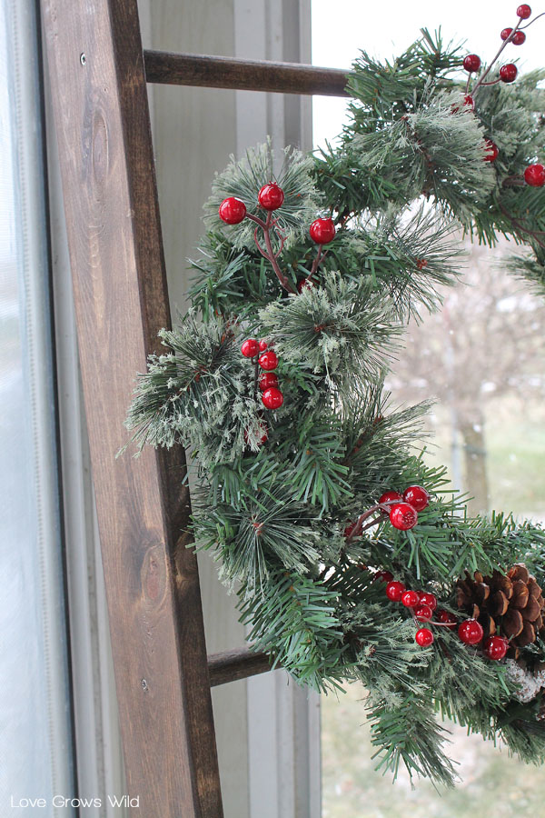 Use a rustic wood ladder to hang a winter wreath for the holidays.