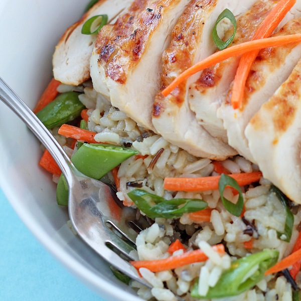 Grilled Citrus Chicken Rice Bowl - Tender grilled chicken, fresh, crisp vegetables, and a tangy citrus dressing come together in a delicious rice bowl!