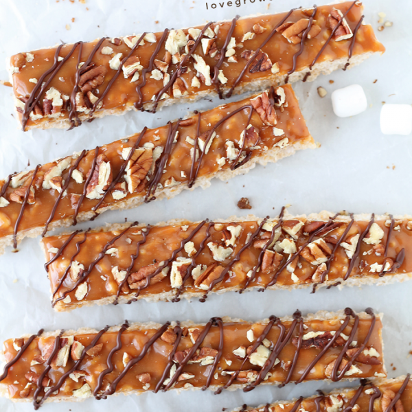 Classic rice krispie treats with a delicious turtle topping of creamy caramel, crunchy pecans, and a decadent chocolate drizzle! | LoveGrowsWild.com