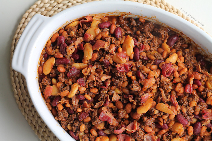 Perfect baked beans made extra meaty with ground beef and bacon! Full of flavor, easy to make, and a great side for parties, cookouts, or tailgating! | LoveGrowsWild.com