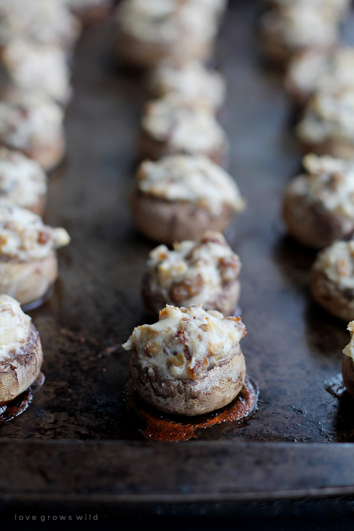 Creamy, delicious Sausage Stuffed Mushrooms make the perfect party appetizer!  Get the recipe for these savory little bites of heaven at LoveGrowsWild.com