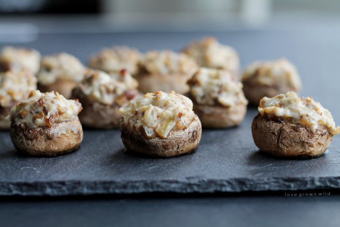 Creamy, delicious Sausage Stuffed Mushrooms make the perfect party appetizer! Get the recipe for these savory little bites of heaven at LoveGrowsWild.com
