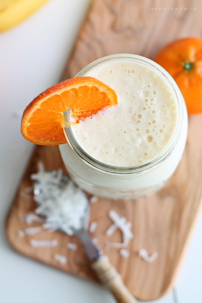 Start your day with a delicious Tropical Smoothie made with orange, banana, pineapple, and coconut! This recipe can be made two ways: plain or green (with spinach)! Click to see more at LoveGrowsWild.com