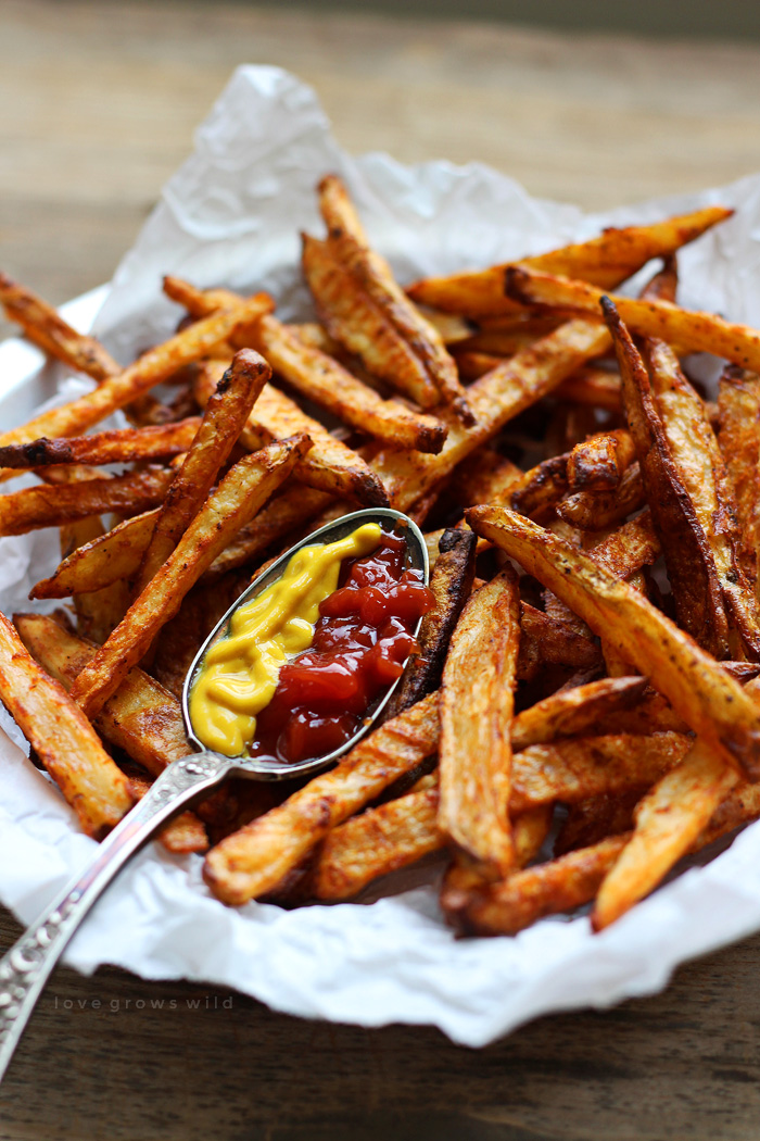 Delicious homemade fries - baked, not fried! - tossed in a spicy seasoning blend! The perfect side to hamburgers, hot dogs, and so much more. | LoveGrowsWild.com