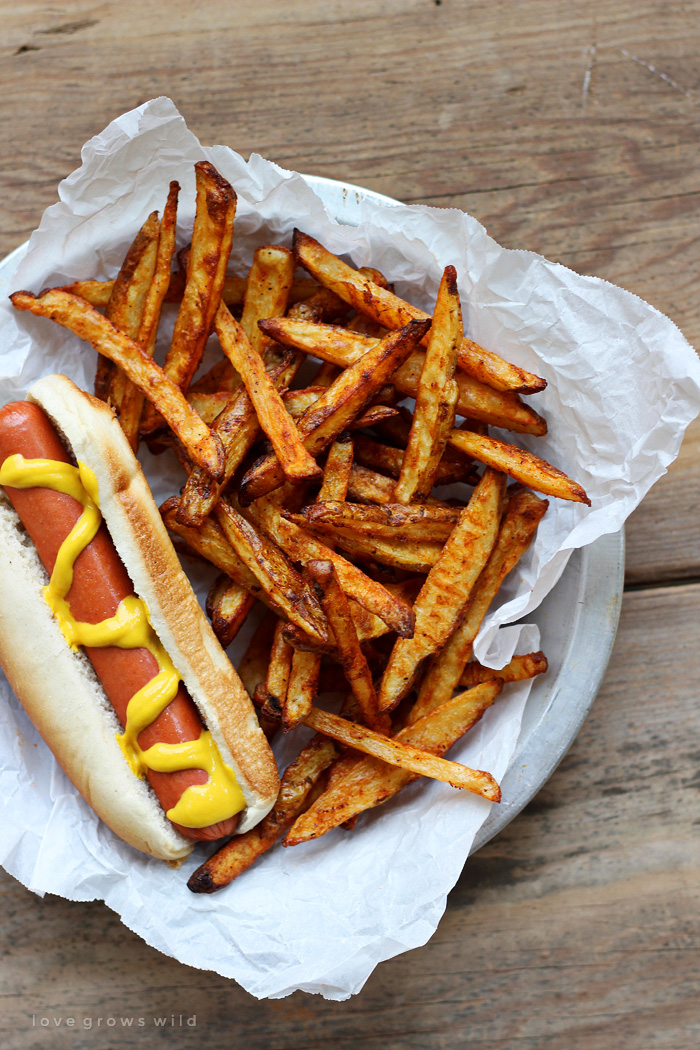 Delicious homemade fries - baked, not fried! - tossed in a spicy seasoning blend! The perfect side to hamburgers, hot dogs, and so much more. | LoveGrowsWild.com