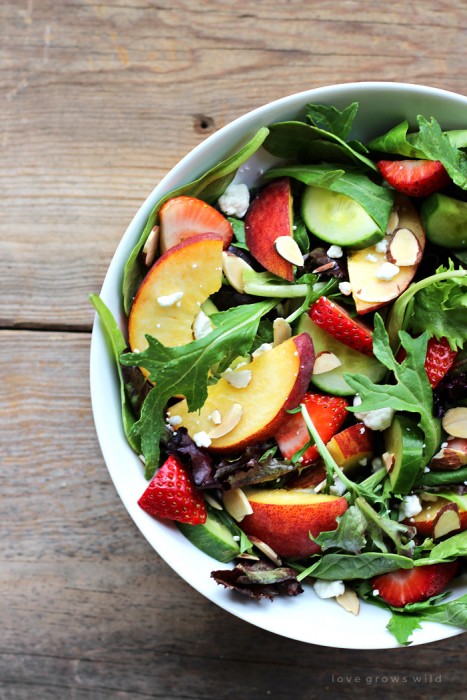 Try this fruity Strawberry Peach Salad for a fresh, fast, and healthy meal any time of day! Fresh greens topped with juicy peaches, ripe strawberries, cucumber, goat cheese, sliced almonds, and a yummy honey balsamic dressing. | LoveGrowsWild.com