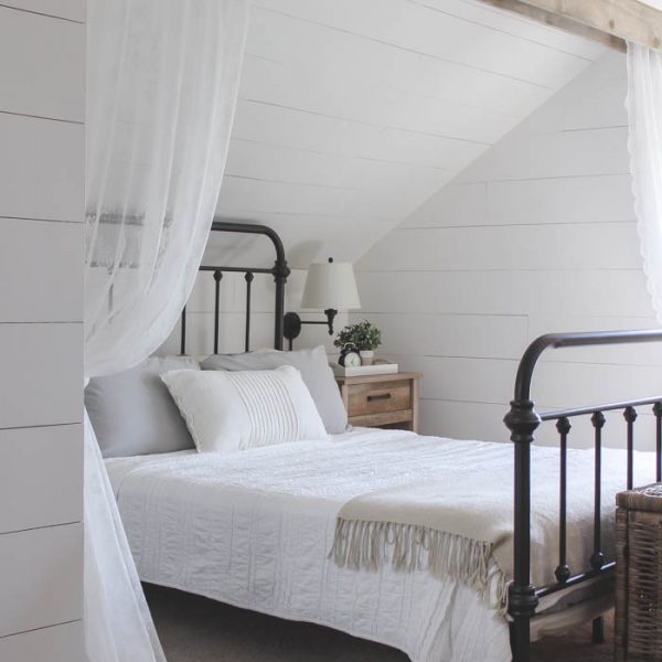 This cozy sleeping nook was created by adding a faux wood beam and lace curtains over the bed, and the results are amazing! See how to do this project in your home at LoveGrowsWild.com