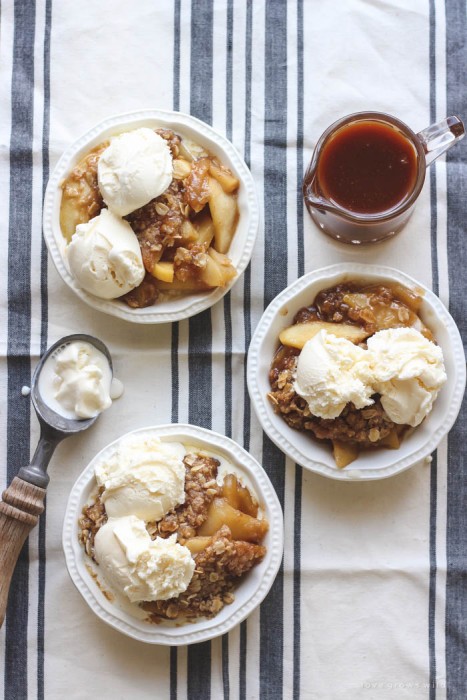Warm salted caramel apple crisp topped with scoops of vanilla ice cream and more salted caramel drizzled over top... the perfect dessert! Get the recipe at LoveGrowsWild.com