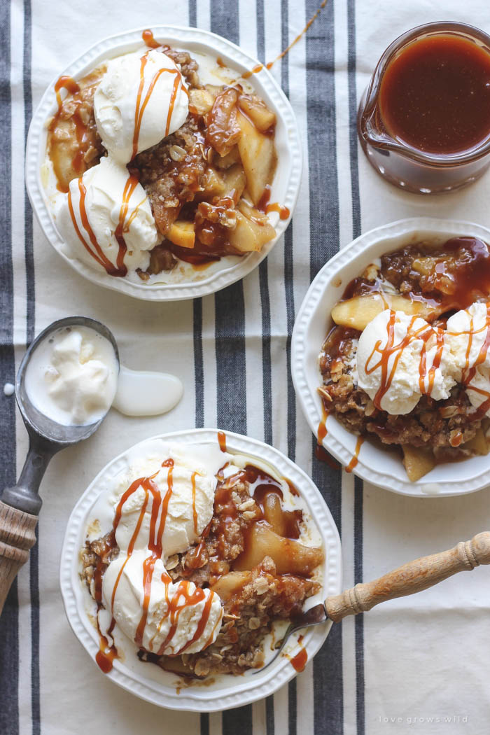 Warm salted caramel apple crisp topped with scoops of vanilla ice cream and more salted caramel drizzled over top... the perfect dessert! Get the recipe at LoveGrowsWild.com