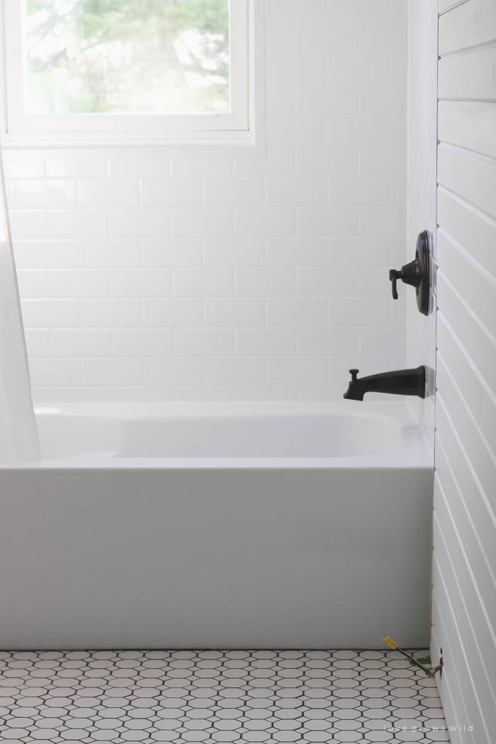 Follow along the big makeover of this beautiful farmhouse bathroom! In this post, Liz shares her tile choice for flooring. Click to see more photos at LoveGrowsWild.com