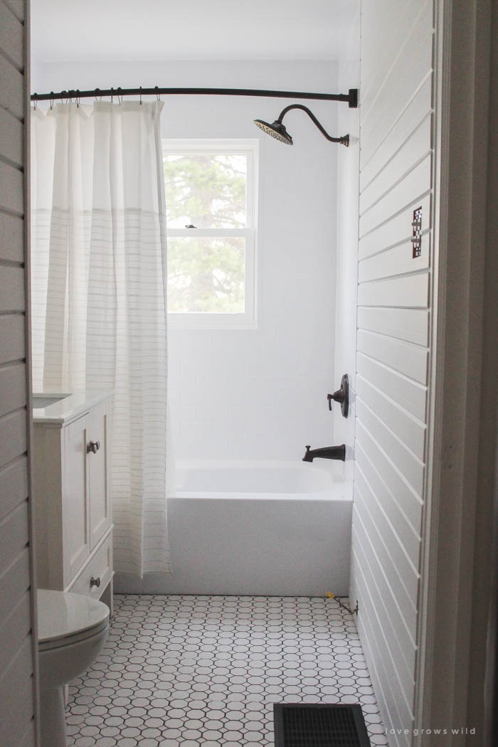 Follow along the big makeover of this beautiful farmhouse bathroom! In this post, Liz reveals her new planked walls, vanity, and closet! Click to see more photos at LoveGrowsWild.com