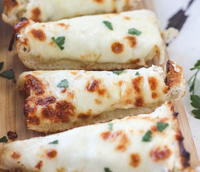 Delicious, extra cheesy garlic bread that is perfectly crusty on the outside and soft and tender on the inside! Find out the secret ingredient at LoveGrowsWild.com