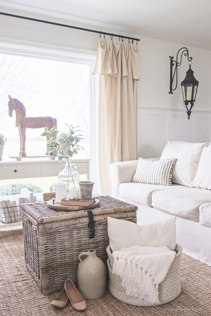 A cozy farmhouse living room with beautiful linen slipcovered sofas. See how to get this custom slipcovered look at LoveGrowsWild.com!