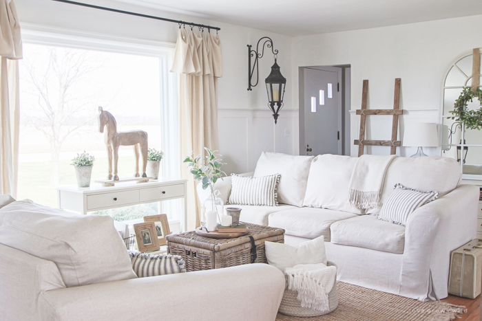 A cozy farmhouse living room with beautiful linen slipcovered sofas. See how to get this custom slipcovered look at LoveGrowsWild.com!