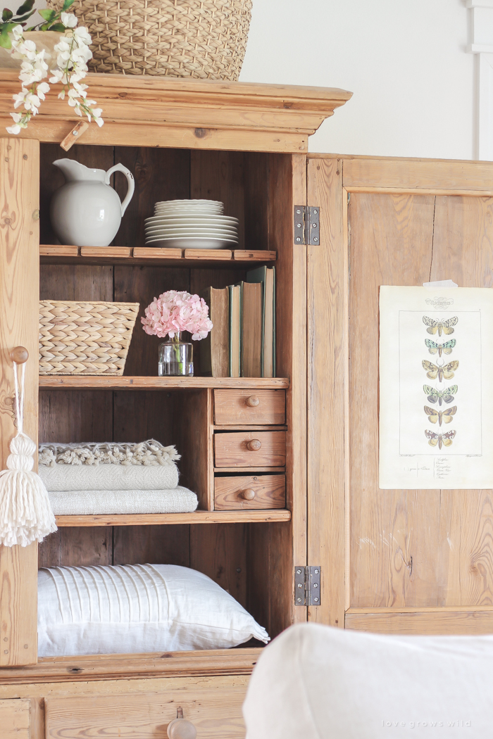 A gorgeous antique armoire decorated for spring in a lovely, little farmhouse. See more photos at LoveGrowsWild.com