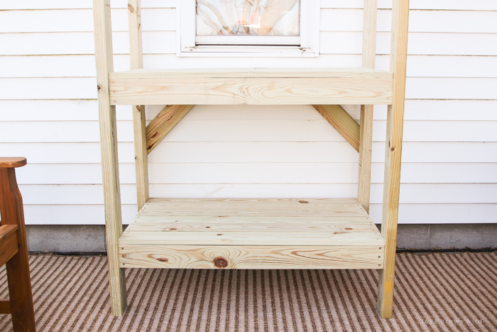 This stunning DIY potting bench is full of charm and perfect for a deck or patio! Use it to hold pots and gardening tools or as a beverage cart when entertaining guests! Full how-to at LoveGrowsWild.com