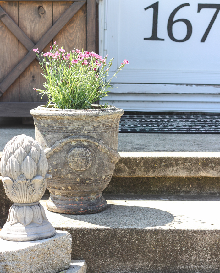 Just because you have a small front porch doesn't mean it can't be big on charm! Get ideas from this beautiful farmhouse at LoveGrowsWild.com