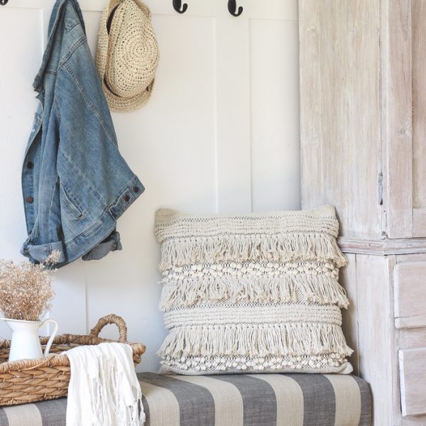 This beautiful farmhouse entryway is the perfect mix of style and organization with a cozy bench, hooks for coat storage, and a basket for accessories.