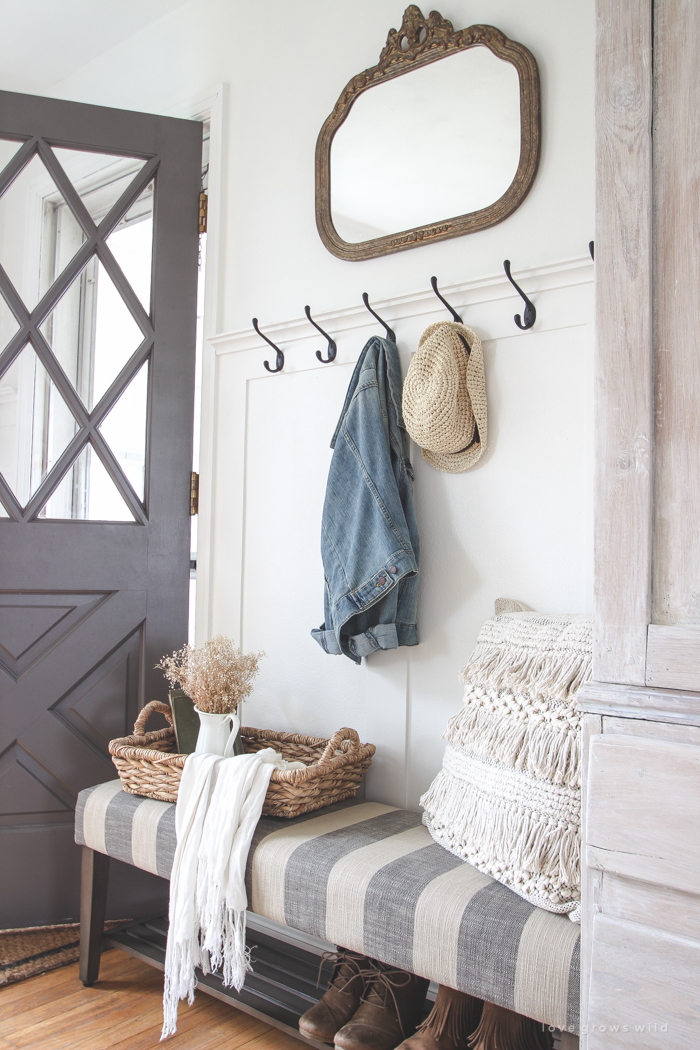 This beautiful farmhouse entryway is the perfect mix of style and organization with a cozy bench, hooks for coat storage, and a basket for accessories. 