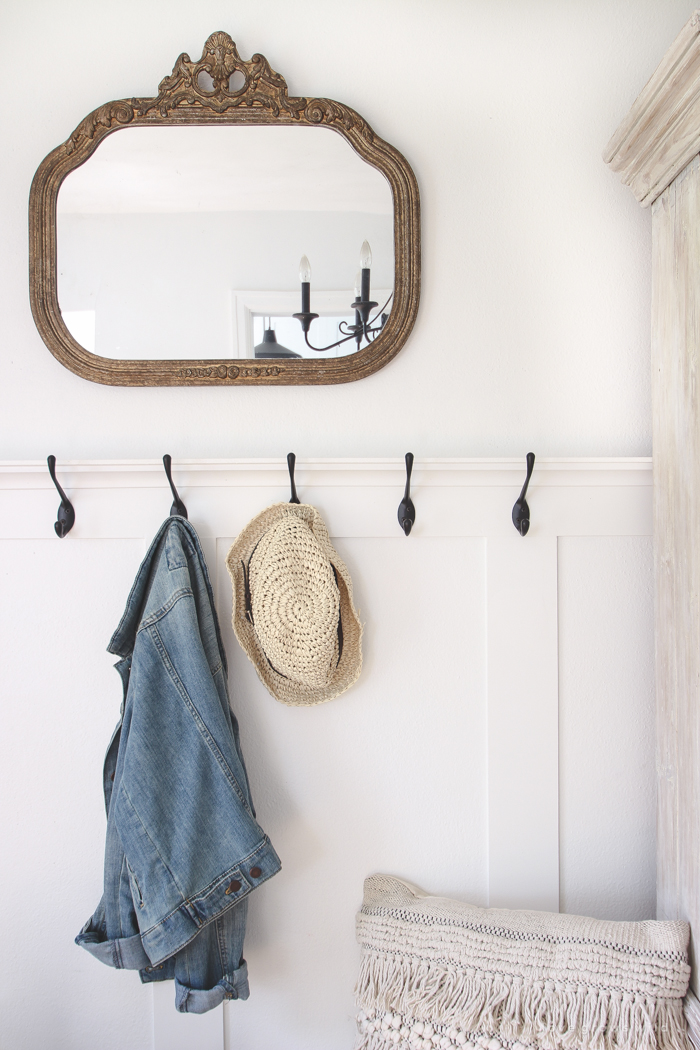 This beautiful farmhouse entryway is the perfect mix of style and organization with a cozy bench, hooks for coat storage, and a basket for accessories. 