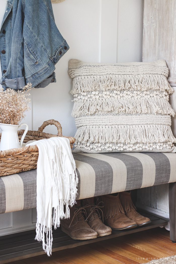 This beautiful farmhouse entryway is the perfect mix of style and organization with a cozy bench, hooks for coat storage, and a basket for accessories. 