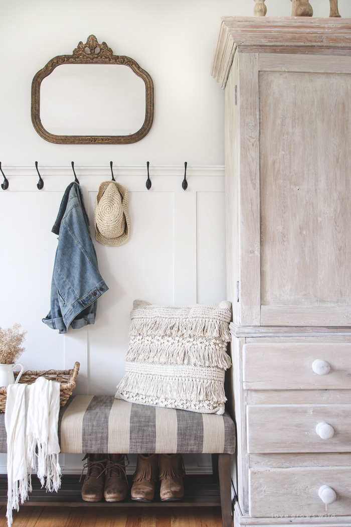 This beautiful farmhouse entryway is the perfect mix of style and organization with a cozy bench, hooks for coat storage, and a basket for accessories.