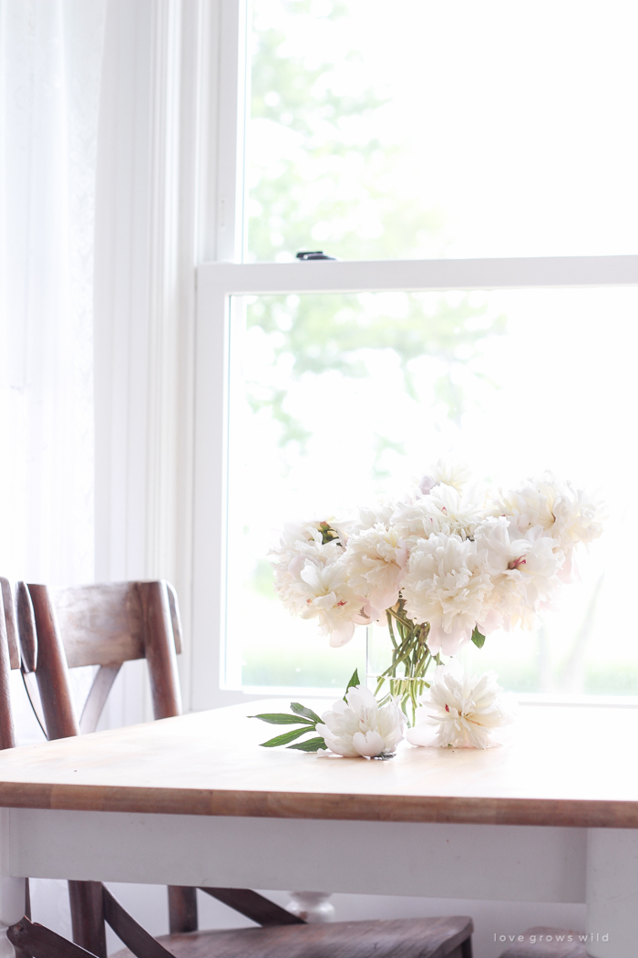 Freshly picked peonies decorate this beautiful farmhouse kitchen by Liz Fourez