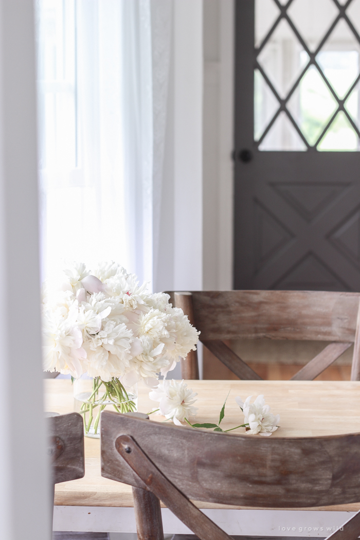 Freshly picked peonies decorate this beautiful farmhouse kitchen by Liz Fourez