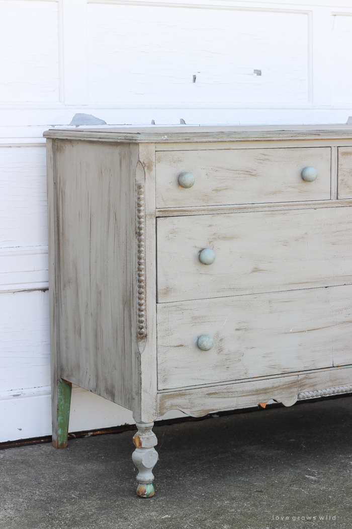 An old dresser gets a makeover with soft blue paint and a delicate hand painted design