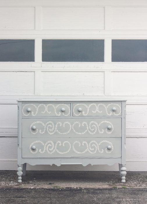 An old dresser gets a makeover with soft blue paint and a delicate hand painted design