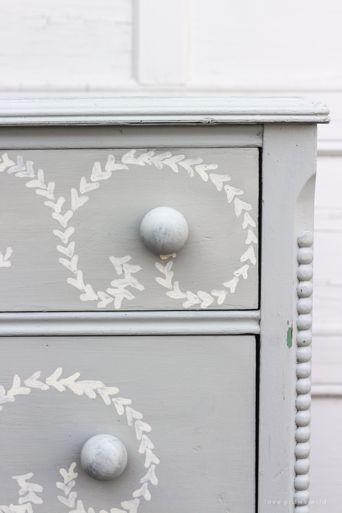 An old dresser gets a makeover with soft blue paint and a delicate hand painted design