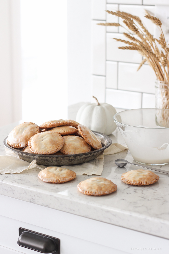 Maple Glazed Pumpkin Hand Pies - Adorable mini pies with cinnamon infused pumpkin filling wrapped in flaky pie crust and topped with a sweet maple glaze!