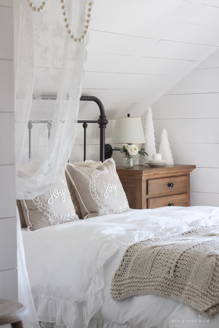 This cozy master bedroom is beautifully decorated for Christmas with soft neutrals and tons of farmhouse charm. 
