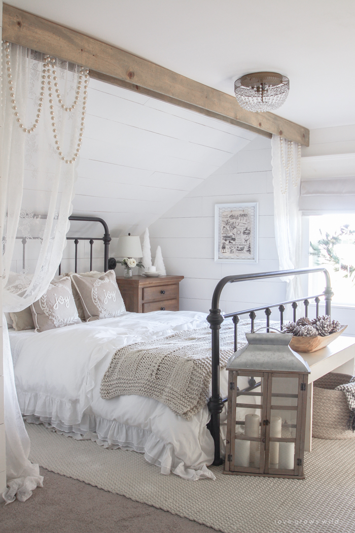 This cozy master bedroom is beautifully decorated for Christmas with soft neutrals and tons of farmhouse charm. 