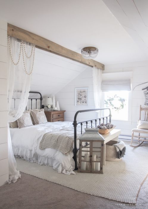 This cozy master bedroom is beautifully decorated for Christmas with soft neutrals and tons of farmhouse charm.