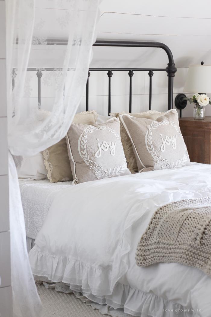 This cozy master bedroom is beautifully decorated for Christmas with soft neutrals and tons of farmhouse charm. 