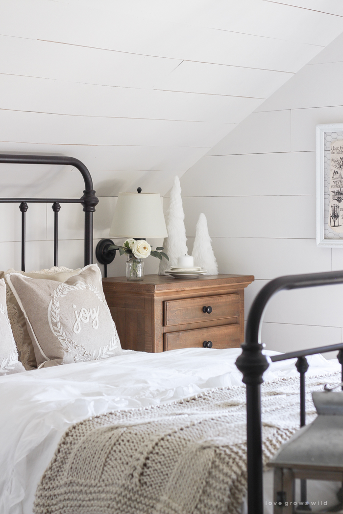 This cozy master bedroom is beautifully decorated for Christmas with soft neutrals and tons of farmhouse charm.