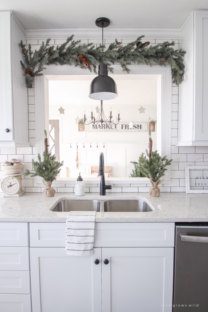 Step inside this beautiful farmhouse and discover a winter wonderland themed kitchen decorated for Christmas with simple touches of greenery and winter charm!