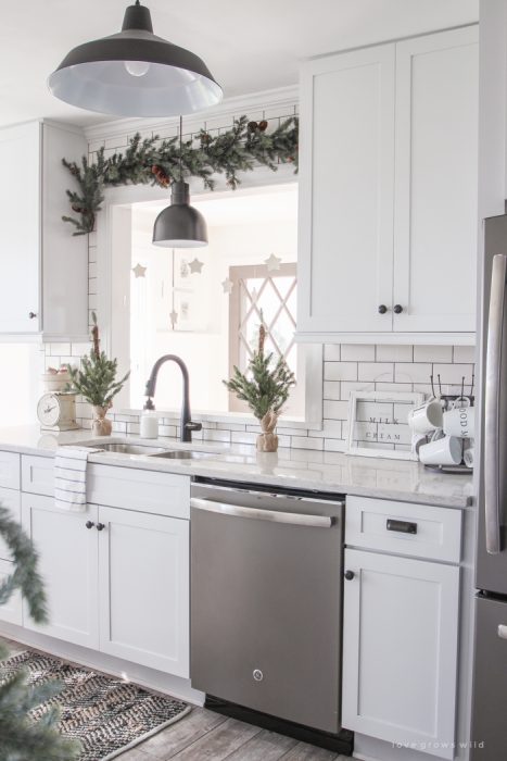 Step inside this beautiful farmhouse and discover a winter wonderland themed kitchen decorated for Christmas with simple touches of greenery and winter charm!