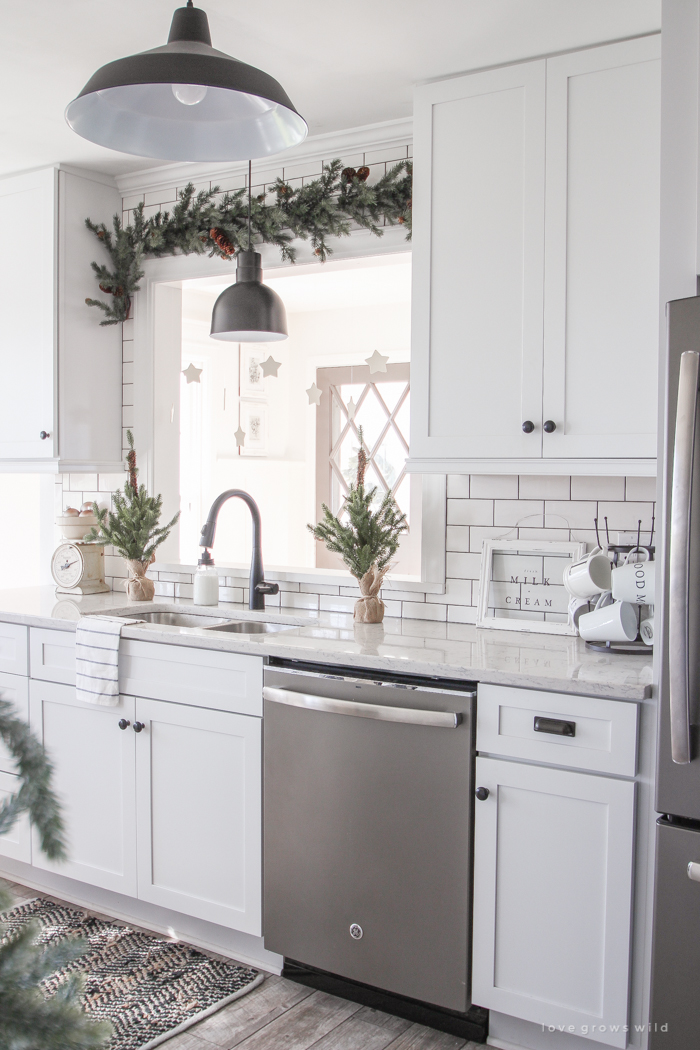 Step inside this beautiful farmhouse and discover a winter wonderland themed kitchen decorated for Christmas with simple touches of greenery and winter charm!