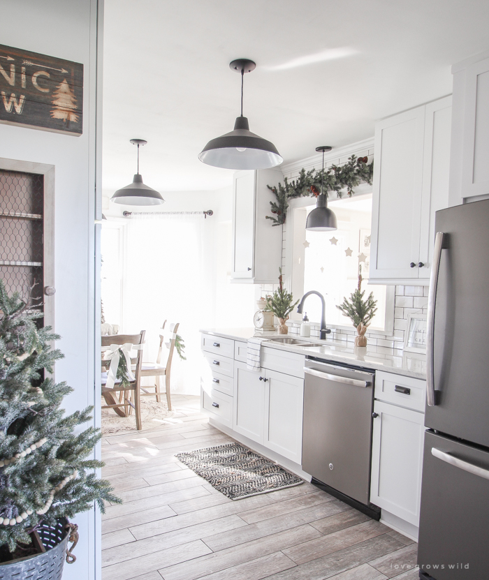 Step inside this beautiful farmhouse and discover a winter wonderland themed kitchen decorated for Christmas with simple touches of greenery and winter charm!