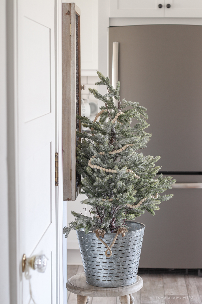 Step inside this beautiful farmhouse and discover a winter wonderland themed kitchen decorated for Christmas with simple touches of greenery and winter charm!