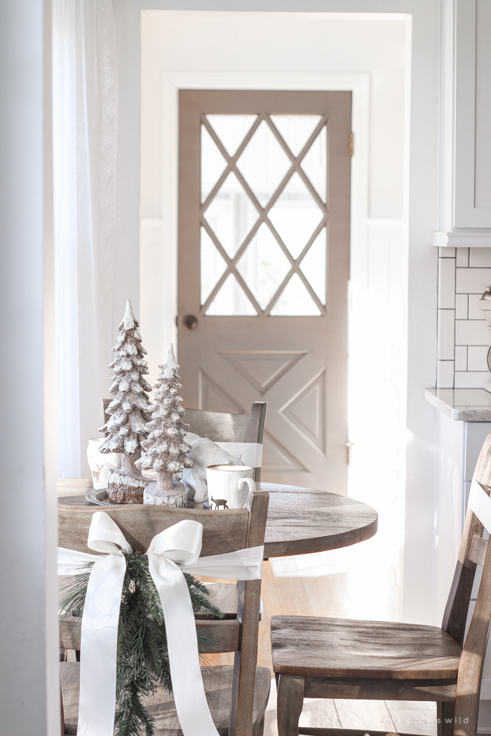 Step inside this beautiful farmhouse and discover a winter wonderland themed kitchen decorated for Christmas with simple touches of greenery and winter charm!