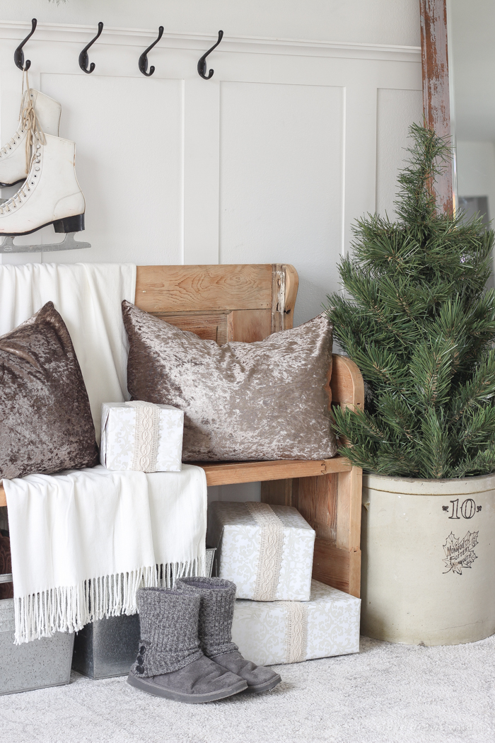 A simple winter white entryway decorated for the holidays in a beautiful farmhouse