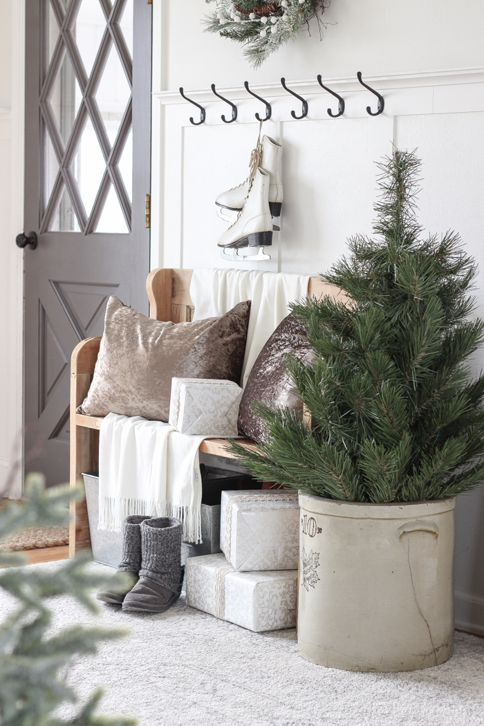 A simple winter white entryway decorated for the holidays in a beautiful farmhouse