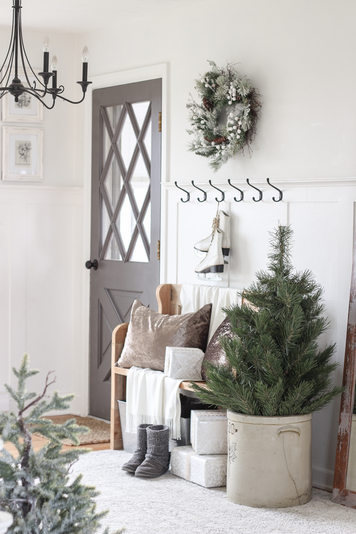 A simple winter white entryway decorated for the holidays in a beautiful farmhouse