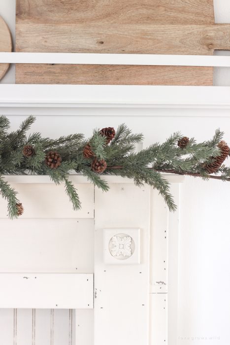 A rustic mantel is given a big makeover for the holidays! See how milk paint transformed this cozy cottage mantel.