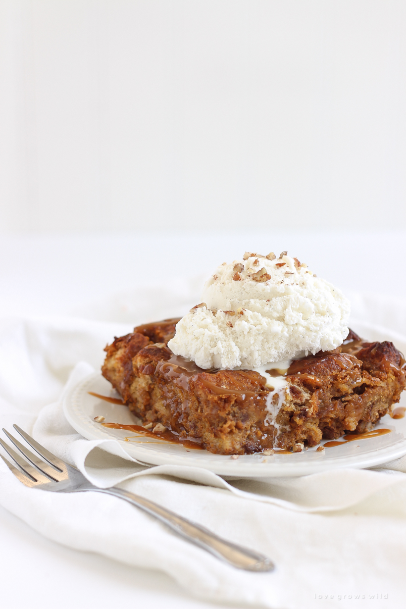 Warm pumpkin bread pudding fresh out of the oven served a la mode with a drizzle of salted caramel and chopped pecans sprinkled on top. Get the recipe at LoveGrowsWild.com