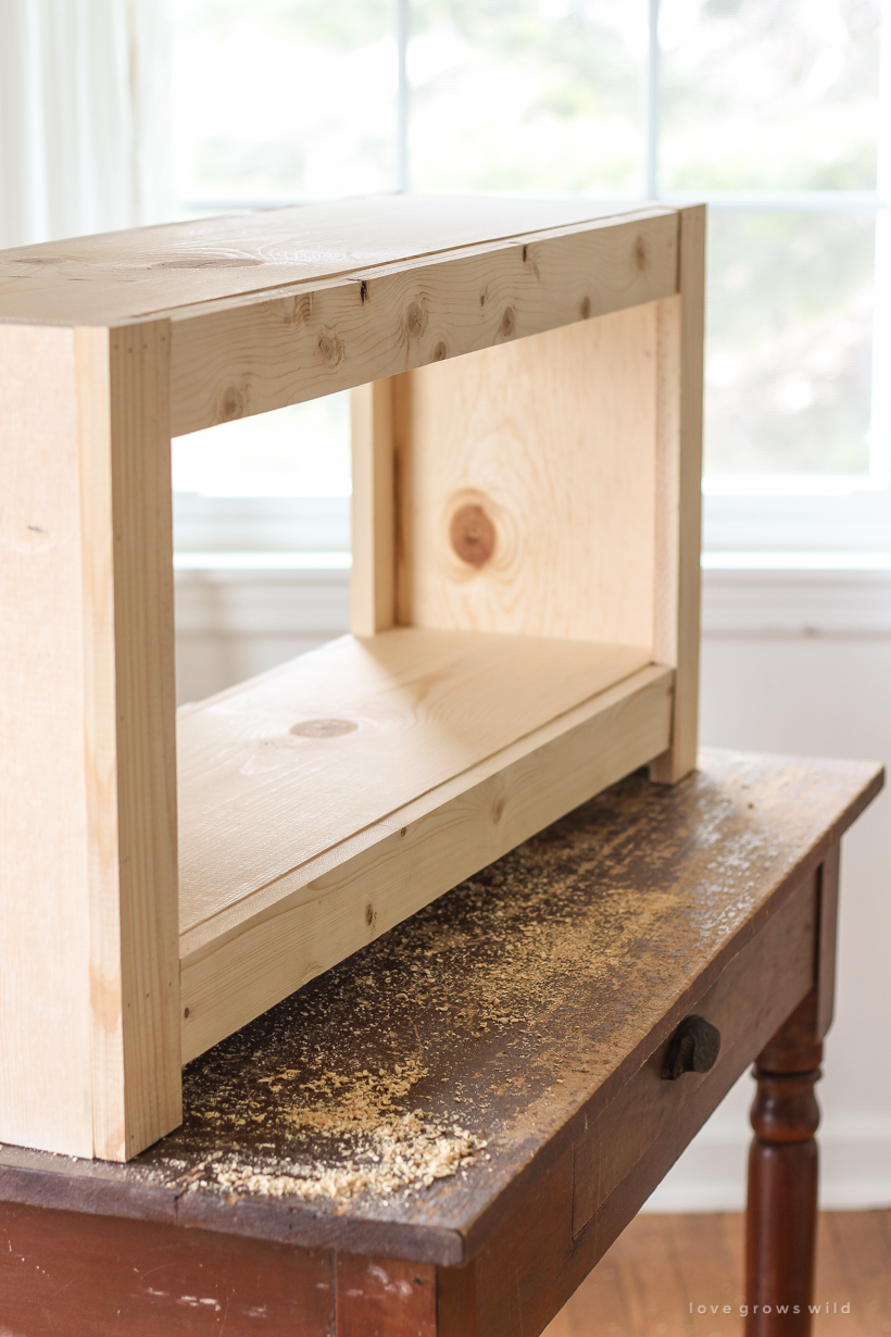 Home and lifestyle blogger Liz Fourez shows how to make a simple bench with storage that would be perfect for an entryway or at the foot of a bed. Follow her easy step-by-step photo tutorial to create this beautiful DIY bench!