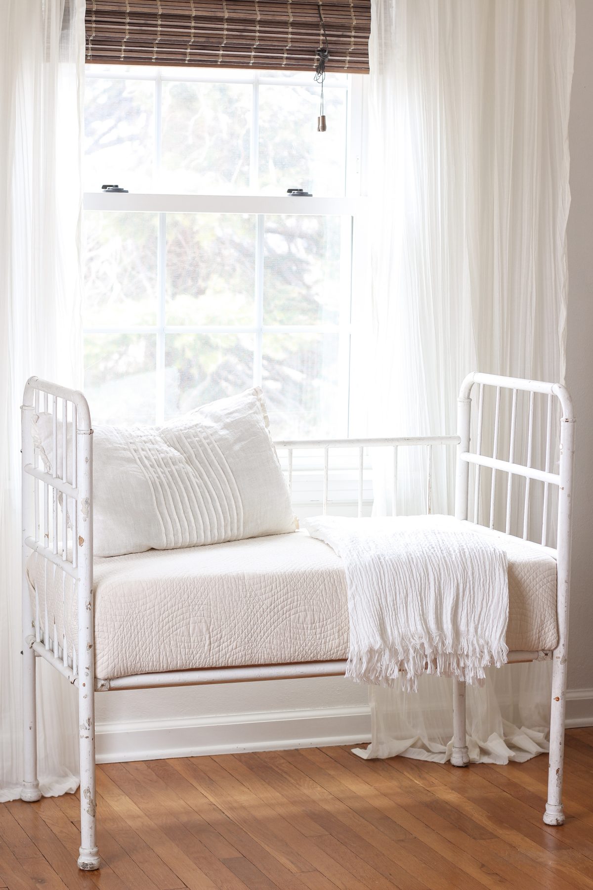 Home and lifestyle blogger Liz Fourez turns a wooden antique crib into an adorable bench with a quilted cushion.